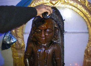 Lord Shani being offered mustard oil