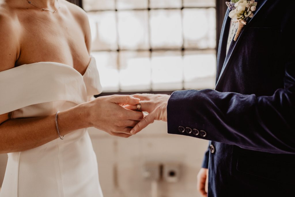 A Bride Putting a Wedding Ring On Groom's Finger